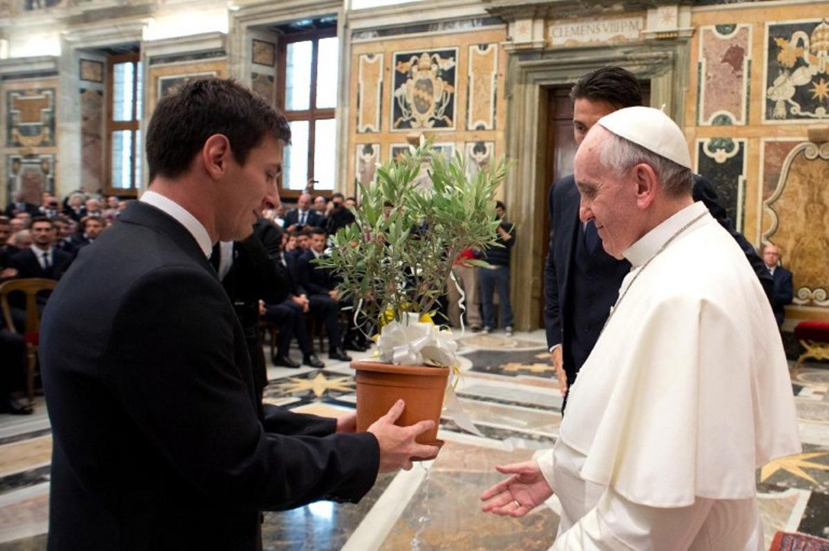 Pope Francis (C) receives an olive tree from Argentine forward Lionel Messi (L) at the end of a private audience together at the Vatican on August 13, 2013. Argentina's national football team will play a friendly match against Italy's national football team on August 14, 2013. AFP PHOTO/ OSSERVATORE ROMANO RESTRICTED TO EDITORIAL USE - MANDATORY CREDIT "AFP PHOTO / OSSERVATORE ROMANO " - NO MARKETING / NO ADVERTISING CAMPAIGNS - DISTRIBUTED AS A SERVICE TO CLIENTS HO / OSSERVATORE ROMANO / AFP