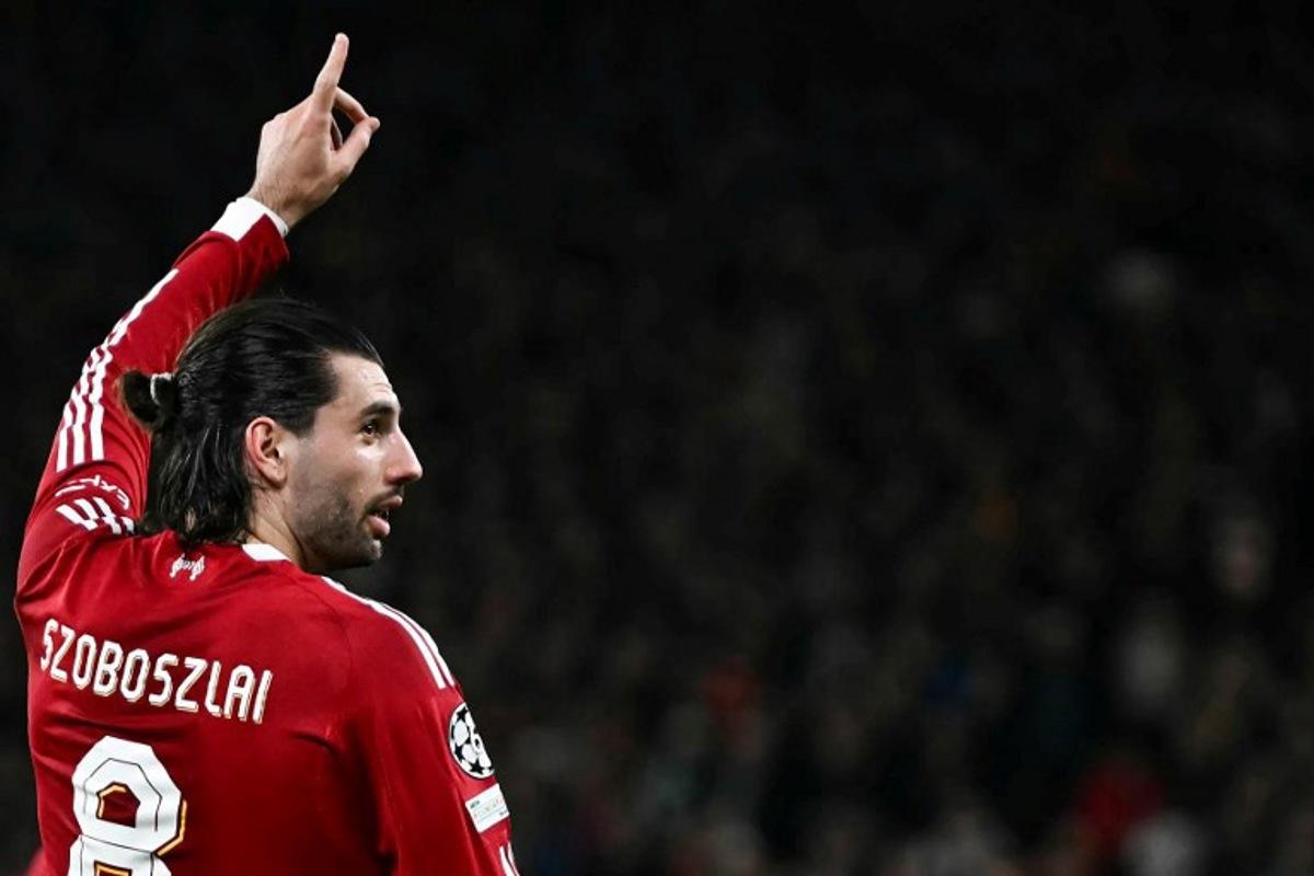 Liverpool's Hungarian midfielder #08 Dominik Szoboszlai celebrates scoring his team's first goal during the UEFA Champions League, round of 16 second leg football match between Liverpool and Galatasaray at Anfield in Liverpool, north-west England on March 18, 2026. Paul ELLIS / AFP