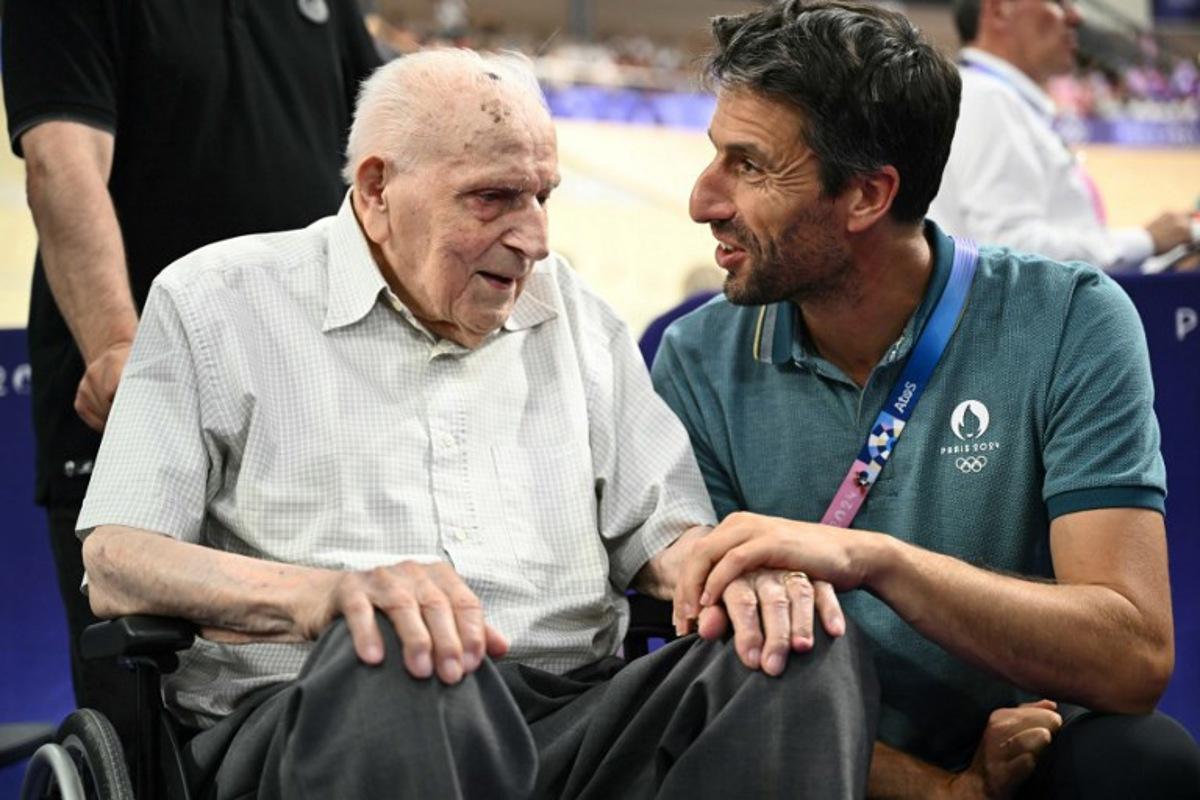 Paris 2024 Olympics and Paralympics Organising Committee (Cojo) chairman Tony Estanguet (R) speaks with French former cyclist Charles Coste ahead of a sessions of the track cycling event of the Paris 2024 Olympic Games at the Saint-Quentin-en-Yvelines National Velodrome in Montigny-le-Bretonneux, south-west of Paris, on August 7, 2024. SEBASTIEN BOZON / AFP
