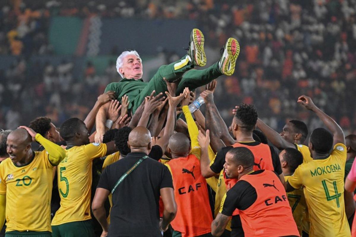 South Africa's head coach Hugo Broos is lifted in the air by South African players after they won the Africa Cup of Nations (CAN) 2024 third place play-off football match between South Africa and Democratic Republic of Congo at Felix Houphouet-Boigny Stadium in Abidjan on February 10, 2024. Sia KAMBOU / AFP