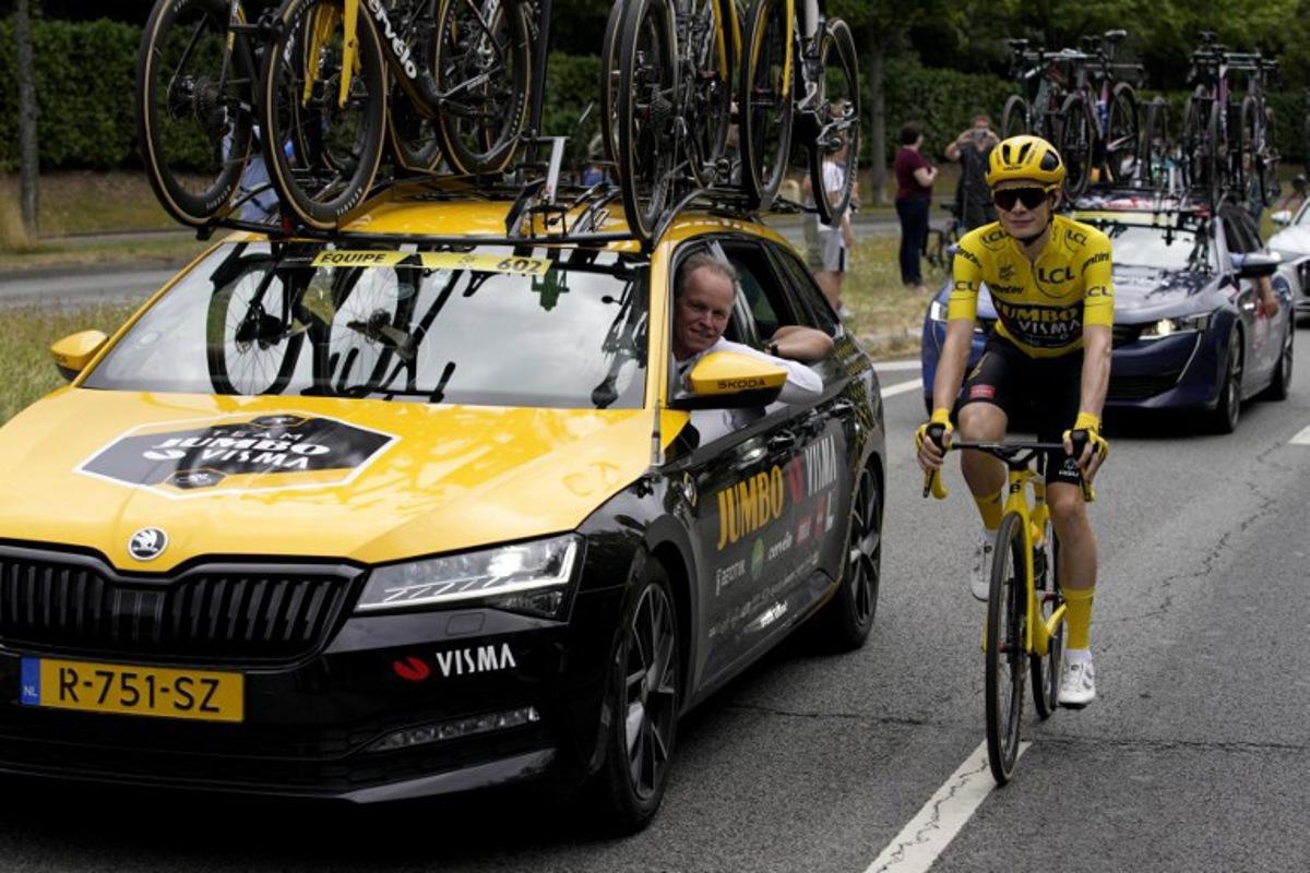 Jumbo-Visma's Danish rider Jonas Vingegaard wearing the overall leader's yellow jersey cycles next to Jumbo-Visma's Dutch General manager Richard Plugge during the 21st and final stage of the 110th edition of the Tour de France cycling race, 115 km between Saint-Quentin-en-Yvelines and the Champs-Elysees in Paris, on July 23, 2023. Daniel Cole / AFP