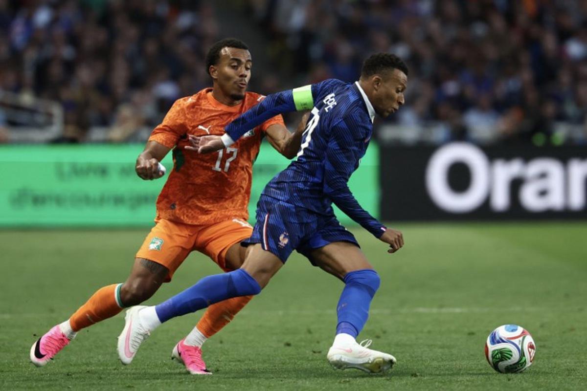 Ivory Coast's defender #17 Guela Doue (L) fights for the ball with France's forward #10 Kylian Mbappe during the international friendly football match between France and Ivory Coast ahead of the 2026 FIFA World Cup football tournament at the Stade de la Beaujoire in Nantes, western France, on June 4, 2026. FRANCK FIFE / AFP