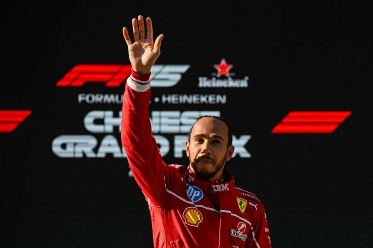 Ferrari's British driver Lewis Hamilton waves as he celebrates taking pole position after the sprint qualifying session of the Formula One Chinese Grand Prix at the Shanghai International Circuit in Shanghai on March 21, 2025. GREG BAKER / AFP