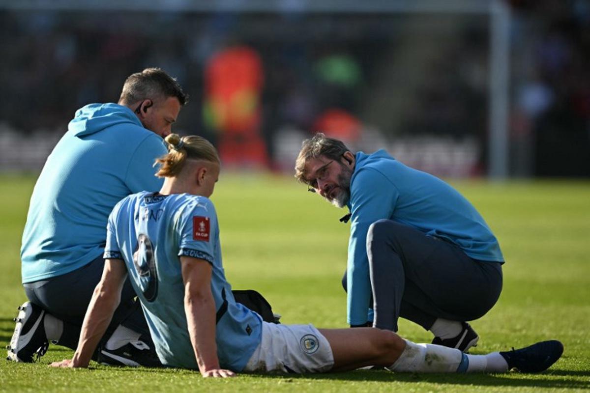 Manchester City's Norwegian striker #09 Erling Haaland receives medical attention after picking up an injury during the English FA Cup quarter-final football match between Bournemouth and Manchester City at the Vitality Stadium in Bournemouth, on the south coast of England on March 30, 2025. JUSTIN TALLIS / AFP